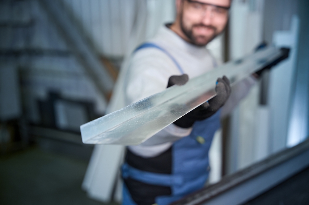 hombre con overol sosteniendo perfil de aluminio